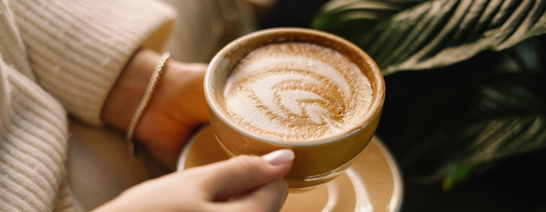 a person holding a cup of coffee