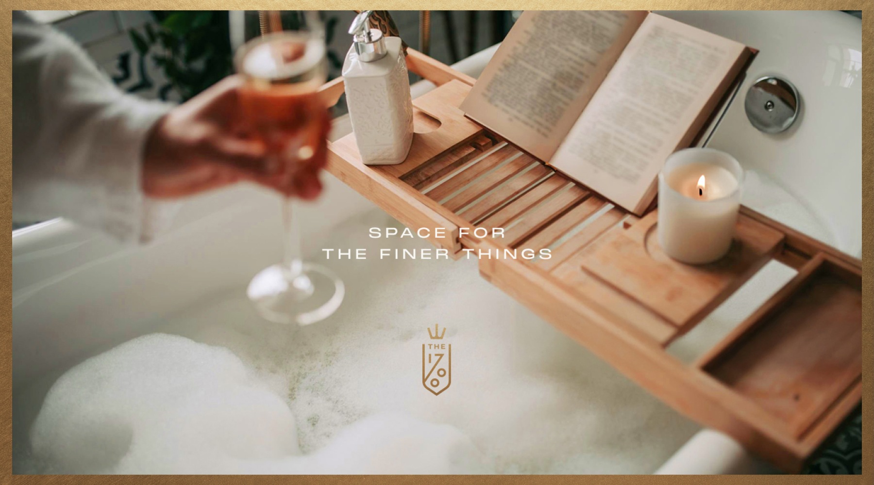 a woman holding a glass of wine over a bubbly bath